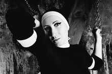 The Torments Of A Sinful Nun In Black Clothes And White Stockings Chained To An Oblique Cross As Punishment