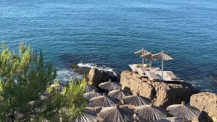 Canvas Print - Beach umbrellas on the rocky sea shore at summer.