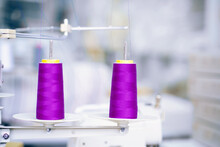 Purple Spools Of Thread For Sewing Machine In Production Workshop.