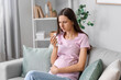 © Pixel-Shot - Young pregnant woman with nosebleed and tissue at home