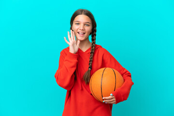 Wall Mural - Little caucasian girl playing basketball isolated on blue background shouting with mouth wide open