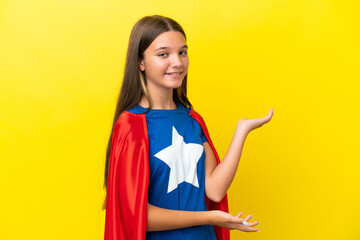 Wall Mural - Little caucasian superhero girl isolated on yellow background extending hands to the side for inviting to come