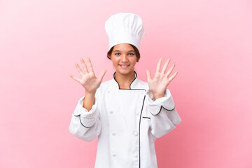 Poster - Little caucasian chef girl isolated on pink background counting ten with fingers