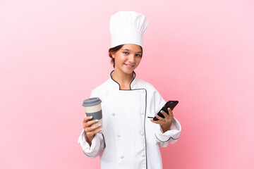 Poster - Little caucasian chef girl isolated on pink background holding coffee to take away and a mobile