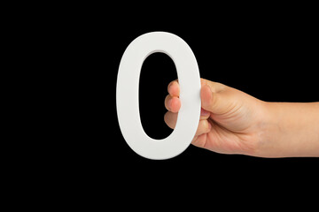 Fototapete - Zero in hand. The number zero is clasped in a hand isolated on a black background. Number zero white in a child's hand on a black background.