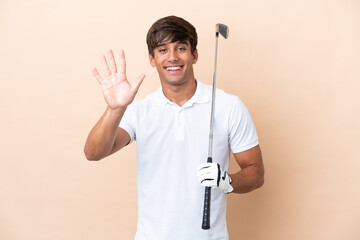 Young golfer player man isolated on ocher background counting five with fingers