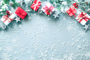 Wall Mural - winter fir branches, evergreen plants, berries, gift boxes and decorations on snowy background