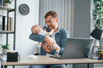 Sticker - Having fun. Father with toddler is indoors in the office