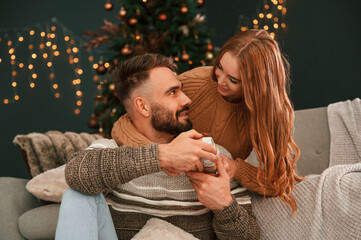 Wall Mural - Closeness of the people. Lovely young couple are celebrating New Year at home