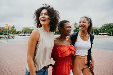 Wall Mural - Three mixed race hispanic and black women bonding outdoors