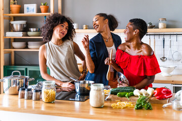 Three mixed race hispanic and black women bonding at home - Multiracial group of happy young female adults spending time together and having fun