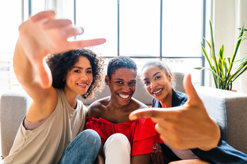 Wall Mural - Three mixed race hispanic and black women bonding at home - Multiracial group of happy young female adults spending time together and having fun