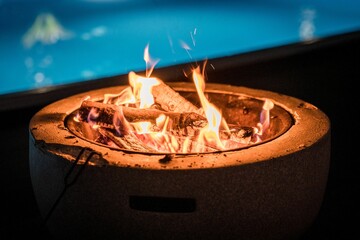 Wall Mural - fire bowl in front of a pool at night