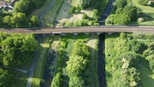 Aerial Shot Over A Railway Viaduct Over A Pair Of Parallel Canals Surrounded By Trees