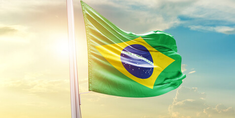 Waving Flag of Brazil in Blue Sky. The symbol of the state on wavy cotton fabric.