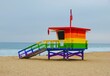 Lifeguard tower painted in rainbow colors in honor of LGBT Pride and pier in the background.