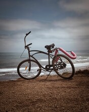 Vertical Shot Of A Bicycle On The Beach Isolated In The Background Of The Sea
