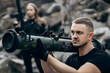 © Alexey - Guy and girl in military with bazooka and machine guns pose for camera