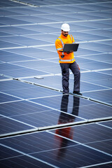 Solar panels installation for sustainable energy. Electrical engineer holding laptop computer with solar panels scheme and checking productivity.