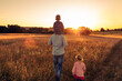 © kieferpix - Father walking in nature meadow with his children. Fatherhood, and family parenting lifestyle concept.