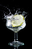 Fototapeta Łazienka - A slice of lemon making a splash in a glass of alcohol