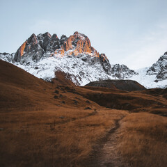 Wall Mural - Beautiful Juta valley hiking route with scenic mountain snowy peak background. Kazbegi national park landscape