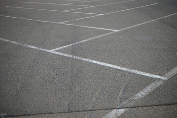 white lines abstract on asphalt, road markings white stripes on the asphalt road, parking spaces separated by white lines, symmetrical abstract lines on gray asphalt