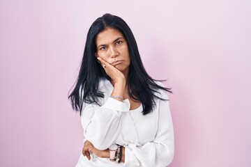 Poster - Mature hispanic woman standing over pink background thinking looking tired and bored with depression problems with crossed arms.