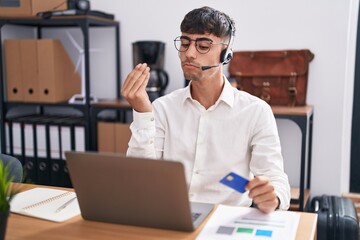 Canvas Print - Young hispanic man working using computer laptop holding credit card doing italian gesture with hand and fingers confident expression