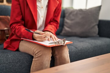 Poster - Young caucasian woman psychologist writing on clipboard at psychology center