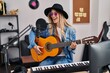 © Krakenimages.com - Young woman musician singing song playing classical guitar at music studio