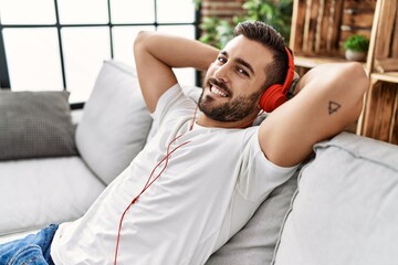 Canvas Print - Young hispanic man smiling confident listening to music at home