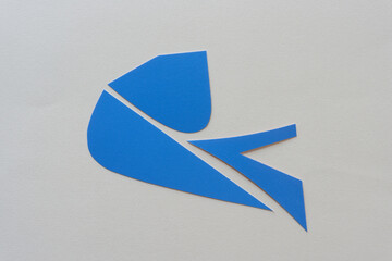 Poster - cut blue paper shapes arranged on blank paper