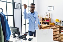 Young African Man Working As Manager At Retail Boutique Angry And Mad Raising Fist Frustrated And Furious While Shouting With Anger. Rage And Aggressive Concept.
