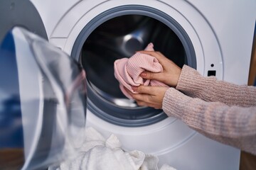 Wall Mural - Young woman washing clothes at laundry room