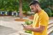 © Krakenimages.com - Young hispanic man smiling confident using smartphone at park