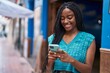© Krakenimages.com - African american woman smiling confident using smartphone at street