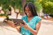 © Krakenimages.com - African american woman smiling confident watching video on touchpad at park