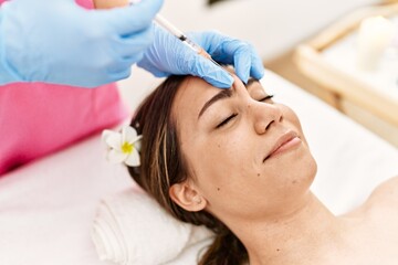 Sticker - Young hispanic woman having anti-aging treatment at beauty center.