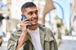 © Krakenimages.com - Young hispanic man smiling confident talking on the smartphone at street