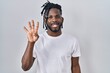 © Krakenimages.com - African man with dreadlocks wearing casual t shirt over white background showing and pointing up with fingers number four while smiling confident and happy.