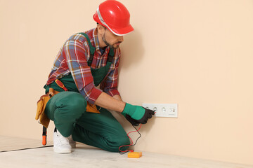 Poster - Electrician in uniform with tester checking voltage indoors