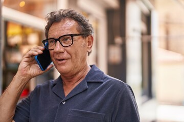 middle age man smiling confident talking on the smartphone at street