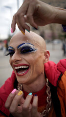 Wall Mural - Drag queen in her colorful clothes strolls through the city listening to music and drinking coffee