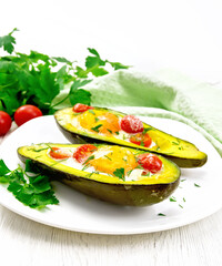 Wall Mural - Scrambled eggs with tomatoes in avocado on table