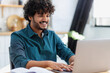 © kucherav - Happy Asian entrepreneur or freelancer, sitting at the table in the home office, working. Remote online work outside the office