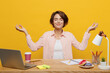 Young employee business woman wear shirt sit work at office desk with pc laptop hold spread hands in yoga om aum gesture meditate isolated on plain yellow color background. Achievement career concept.