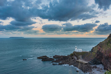Wall Mural - Lovely sunrise landscape image of Devon coastline in England with stunning golden hour light on the land and sky