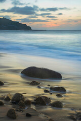 Canvas Print - Stunning landscape image of Sennen Cove in Cornwall during sunset with dramatic sky and long exposure sea motion