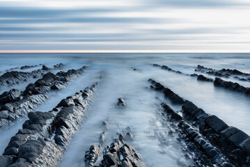 Wall Mural - Beautiful sunset landscape image of Welcome Mouth Beach in Devon England with beautiful rock formations